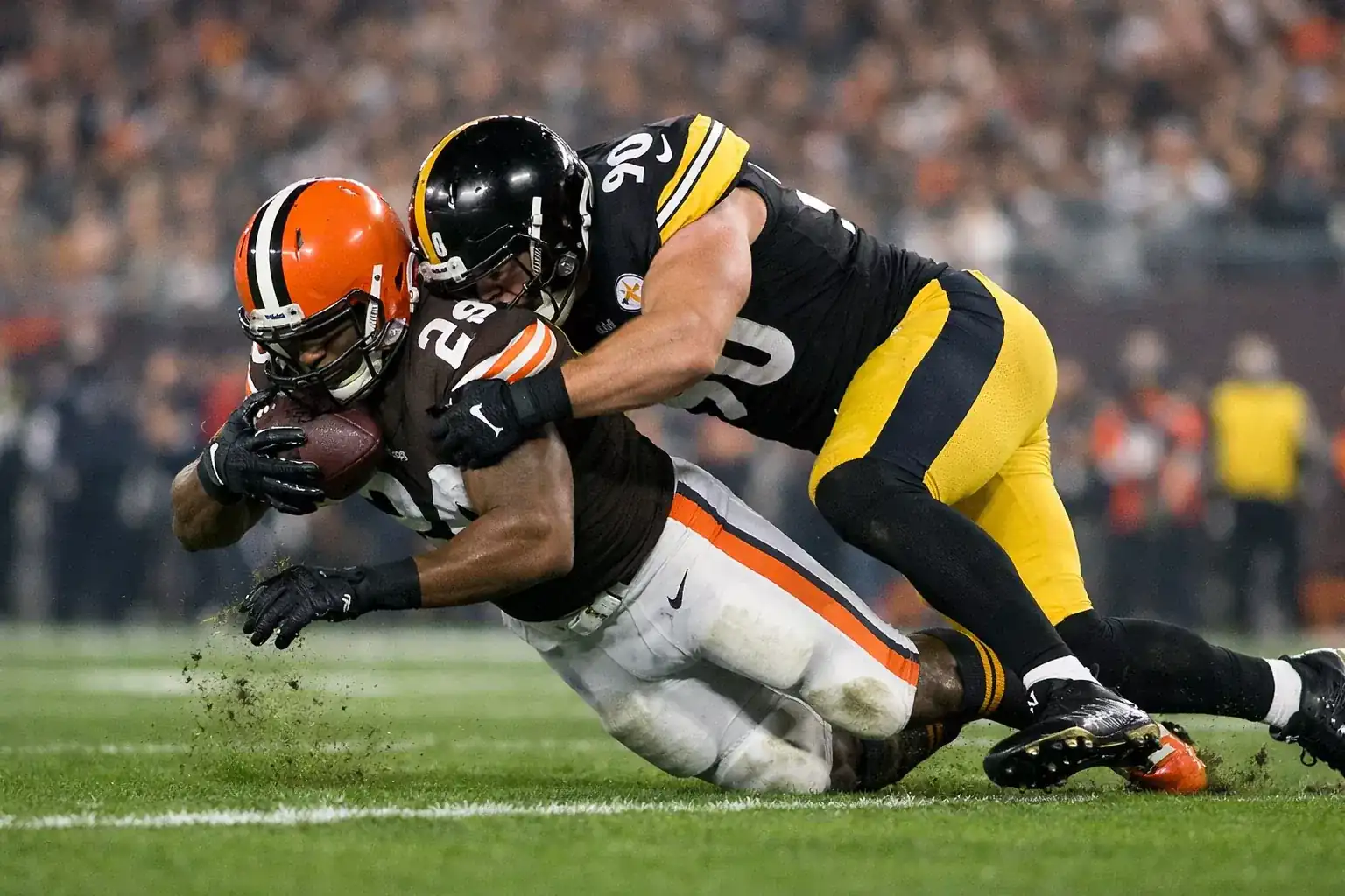 NFL defensive player making tackle during professional football game
