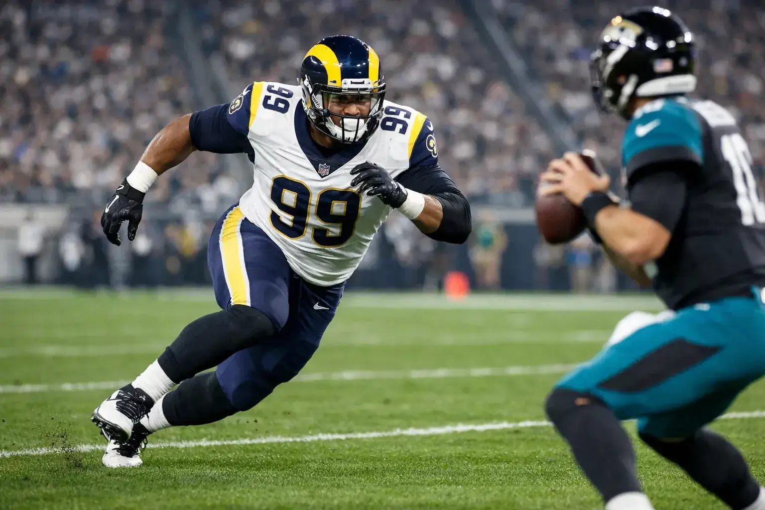 NFL defensive lineman rushing quarterback during professional game