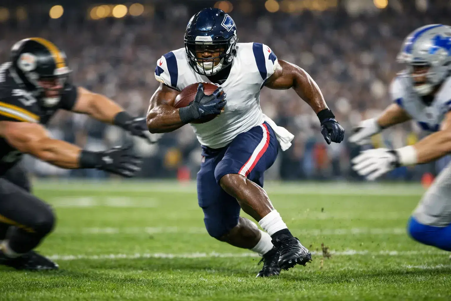 NFL running back carrying football through defensive line on grass field